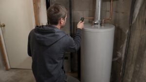 Technician checking the temperature of a residential tank water heater.
